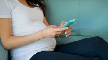 Pregnany lady sat using her mobile phone